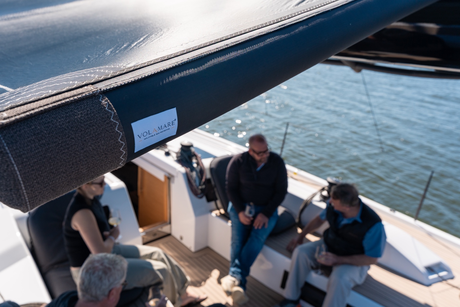 Volamare Sonnenschutz mit sichtbarem Branding und Gästen an Bord